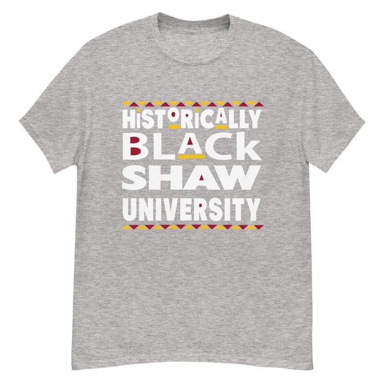 Peut inclure: T-shirt gris avec le texte "Historically Black Shaw University" en lettres blanches avec un motif g&eacute;om&eacute;trique rouge et jaune.
