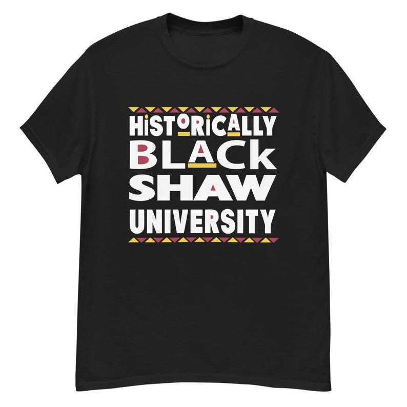 Peut inclure: T-shirt noir avec un texte blanc qui dit "Historically Black Shaw University" avec un motif rouge, jaune et noir.