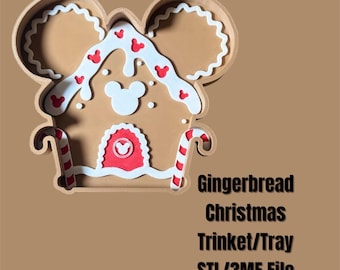 May include: A brown gingerbread house-shaped trinket tray with white and red accents. The tray features a Mickey Mouse head shape and candy cane details. The text "Gingerbread Christmas Trinket/Tray STL/3MF File" is visible.