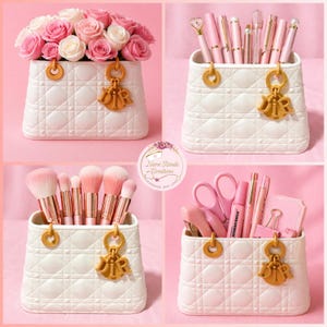May include: A collection of white quilted decorative containers, each adorned with a gold charm. One holds pink and white roses, another pens, a third makeup brushes, and the last, pink office supplies.