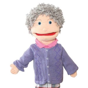 May include: A fabric puppet of an elderly woman with gray curly hair, blue eyes, and a red smiling mouth. She wears a purple cardigan, a pink collared shirt, a plaid skirt, and black shoes. The puppet's arms are outstretched.