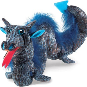 May include: Blue and silver dragon puppet with a long, furry tail and a red tongue. The dragon has large, blue eyes and a scaly body.