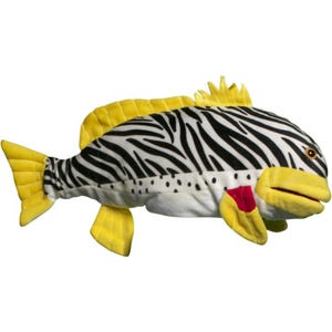 May include: A plush fish toy with a zebra-striped pattern in black and white. The fins and tail are bright yellow, and there is a red accent near the mouth. The toy is designed to resemble a fish.