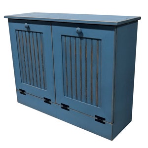 May include: A blue wooden double-door trash can with a distressed finish. The doors have vertical slats and black hinges.