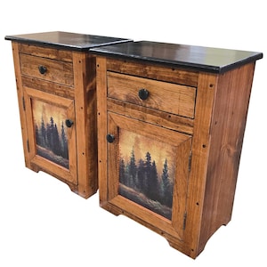 May include: Two wooden nightstands with a rustic design. Each nightstand has a drawer, a cabinet door with a forest scene, and a black top. The nightstands are made of light brown wood with black hardware.