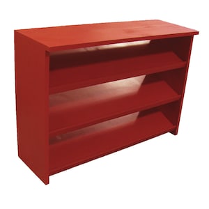 Op de afbeelding: Een rode houten plank met drie planken. De planken zijn licht naar voren gekanteld.