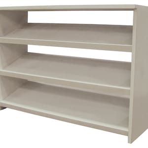 Op de afbeelding: Een witte houten schoenenrek met drie planken. De planken zijn schuin om schoenen te houden.