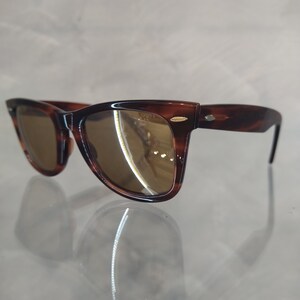 May include: Brown tortoiseshell sunglasses with brown lenses. The sunglasses have a classic, retro style.