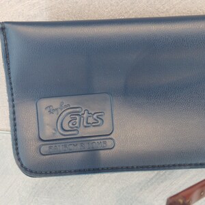 May include: A blue leather case for Ray-Ban Cats sunglasses with the brand name and "BAUSCH & LOMB" embossed on the front.