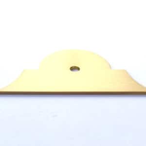 May include: A gold-coloured metal shelf bracket with a decorative top edge and a round hole in the centre.