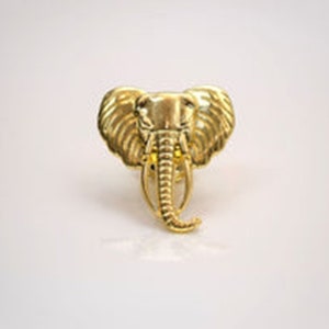 May include: A gold-coloured elephant head ring. The ring is detailed with textured ears and a trunk.