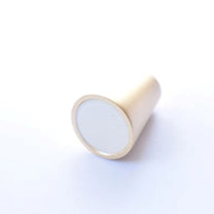May include: A gold-toned cone-shaped cabinet knob with a round, white centre.