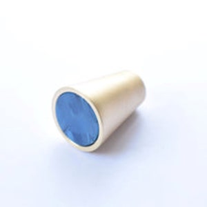 May include: A gold-coloured cone-shaped cabinet knob with a blue circular insert.