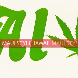 May include: A green graphic with the word "Aloha" in a stylized font, featuring a cannabis leaf in place of the "o". The text "MAUI STYLI HAWAII" is printed in a red rectangle below the word Aloha.