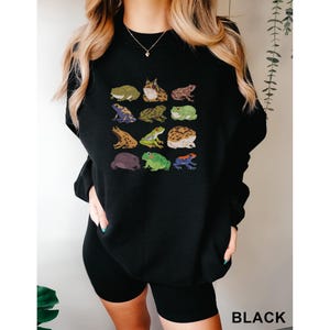 a woman wearing a black sweatshirt with animals on it