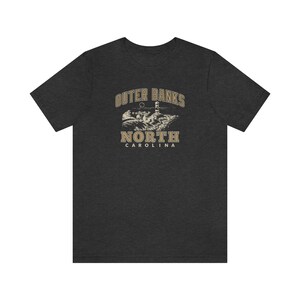 Pode incluir: Camiseta cinza escuro mesclada com um gr&aacute;fico vintage de um farol e o texto "Outer Banks North Carolina".