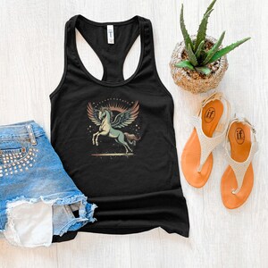 K&ouml;nnte beinhalten: Schwarzes Tanktop mit einem Pegasus-Motiv, kombiniert mit Jeansshorts und orangefarbenen Sandalen. Das Pegasus-Design zeigt ein hellblaues Pferd mit Fl&uuml;geln vor einem Sonnenuntergang. Eine kleine Topfpflanze ist ebenfalls zu sehen.
