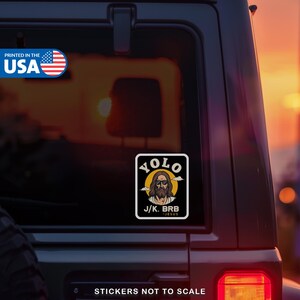 May include: A black and white sticker with the text "YOLO" above an image of Jesus wearing sunglasses. Below the image is the text "J/K. BRB - JESUS". The sticker is printed in the USA.
