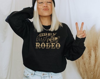 Camiseta engraçada "Não é meu primeiro rodeio" estilo country/western/cowgirl, unissex, com gola redonda.