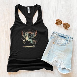 K&ouml;nnte beinhalten: Schwarzes Tanktop mit einem Grafikdesign eines gefl&uuml;gelten Pferdes mit Sonnenmuster. Hellblaue Jeansshorts mit Spitzensaum und braune Sonnenbrille sind ebenfalls zu sehen. Ein l&auml;ssiges Sommeroutfit.