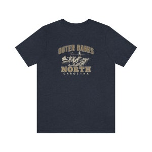 Pode incluir: Uma camiseta azul marinho com um gr&aacute;fico vintage de um farol e o texto "Outer Banks North Carolina".