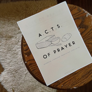 May include: A white printable poster with a black illustration of a book, bowl, and bread. The text "A.C.T.S. OF PRAYER" is in black and the text "ADORATION. CONFESSION. THANKSGIVING. SUPPLICATION" is in smaller black text below the illustration.