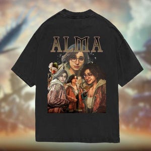 May include: Black t-shirt featuring a graphic print of a group of women. The text "ALMA" is printed in large letters above the graphic.