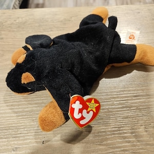 Puede incluir: Juguete de peluche de perro negro y marrón con una etiqueta de Ty Beanie Babies que dice "Beanie Babies Original Baby".