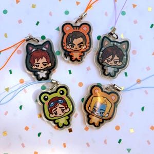 Può includere: Cinque ciondoli in acrilico trasparente con personaggi dei cartoni animati in costume da animali. I ciondoli hanno chiusure in metallo color argento e cordini colorati. I personaggi sono vestiti da tigre, gatto, rana e orso.