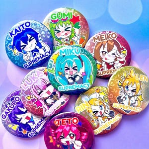 May include: A selection of vibrant, circular badges showcasing anime-style character designs. Each badge displays a different character with unique artwork and the word "SUPREMACY". The badges are in various colours, including blue, green, pink, and yellow.