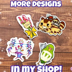 May include: Four colorful stickers featuring a bouquet of pink roses with a yellow ribbon, a cartoon cat with a Totoro-like creature on its back, a cluster of blue and pink coral-like shapes, and a green bird with a white belly and a knife.