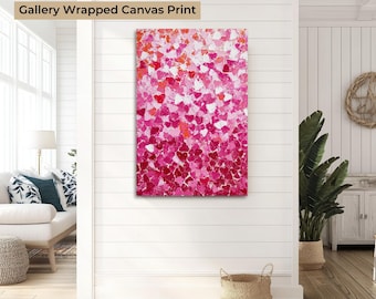 May include: Gallery wrapped canvas print featuring a vibrant abstract design of hearts in shades of pink, red, and white. The artwork is displayed on a white wall, adding a pop of color to the room. The text "Gallery Wrapped Canvas Print" is at the top.