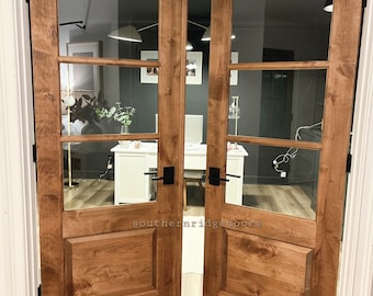 May include: A pair of double French doors with glass panels and a wood frame. The doors are stained a dark brown color and have a raised panel design. The doors are open and the text "southernridgedoors" is visible on the bottom of the doors.