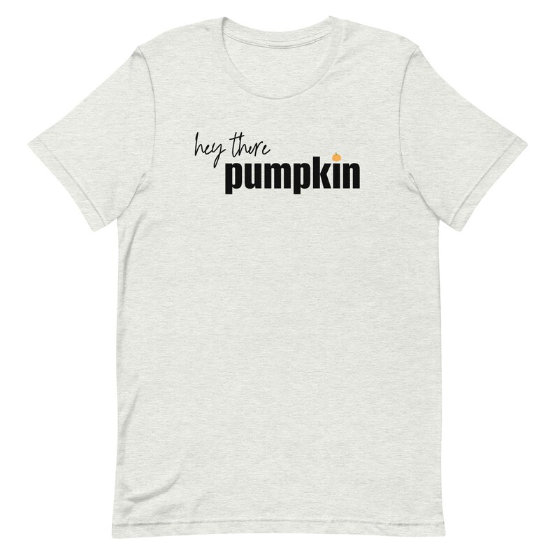 Pode incluir: Camiseta cinza claro com a frase "hey there pumpkin" em letras pretas e em bloco. Um pequeno gr&aacute;fico de ab&oacute;bora laranja est&aacute; acima da palavra "pumpkin". A camiseta &eacute; de gola redonda e manga curta.