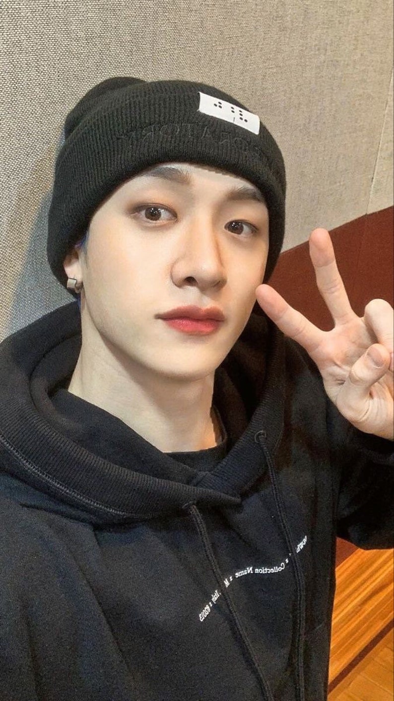 May include: A person wearing a black beanie with a white label that says "..." and a black hoodie with white text that says "Collection Name - M.S. Good x Jail."