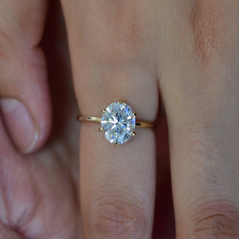 May include: A gold ring with a large, round, clear diamond.