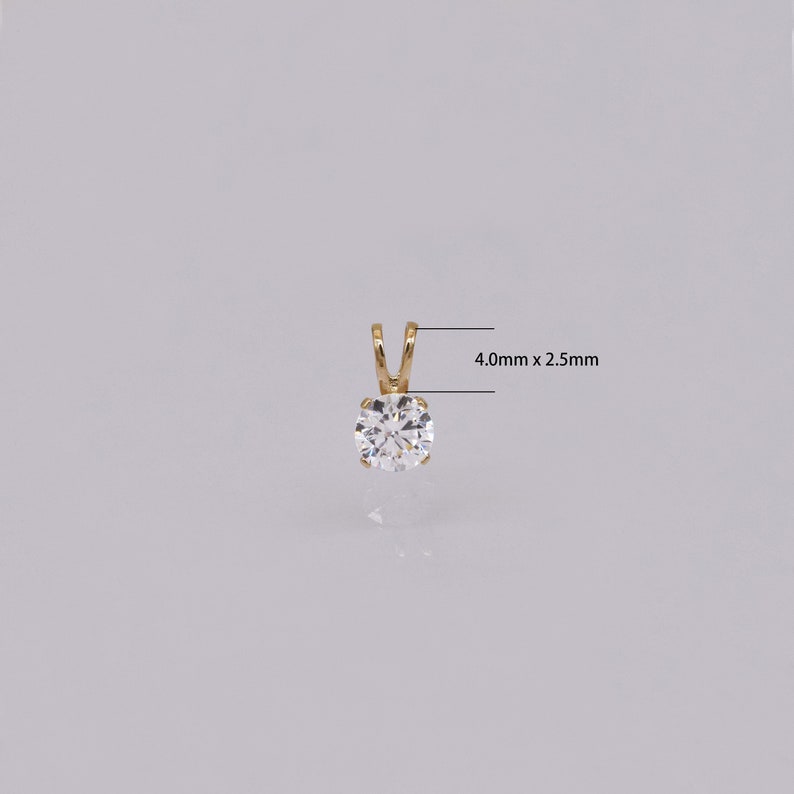 Pu&ograve; includere: Un pendente in oro con una gemma rotonda e trasparente. Il pendente misura 4,0 mm x 2,5 mm. La gemma &egrave; incastonata in un design semplice e classico. Perfetto per l'uso quotidiano o occasioni speciali.