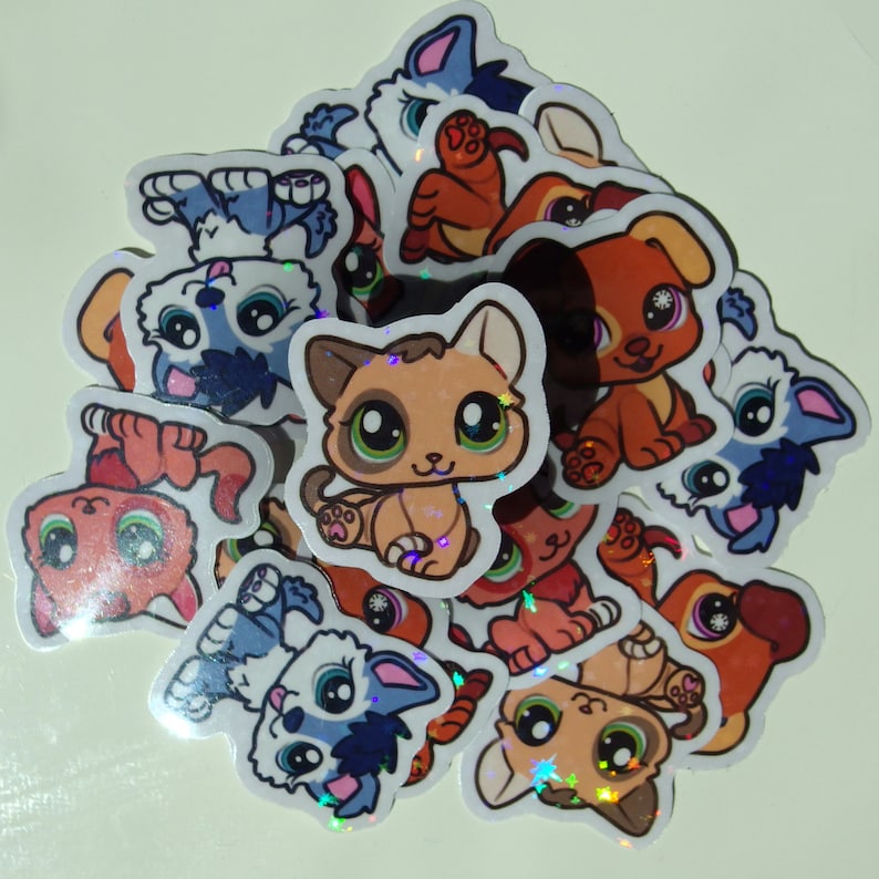 May include: A collection of colorful, glittery stickers featuring cartoon animals. The stickers are shaped like cats, dogs, and other animals. They are perfect for adding a touch of whimsy to any project.