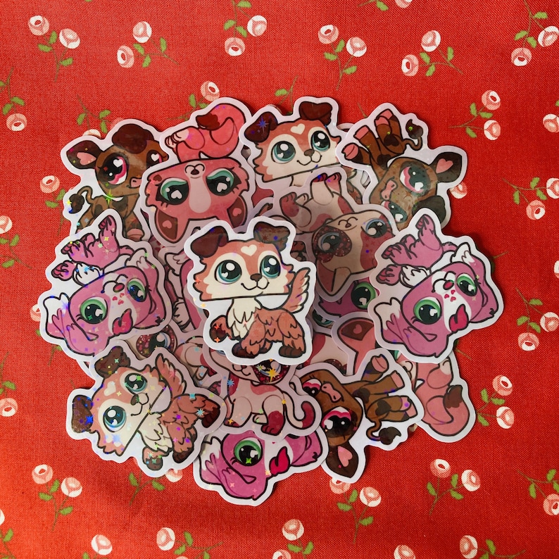 May include: A collection of colorful, glittery stickers featuring cartoon animals. The stickers are mostly pink and white with some brown and black accents. The animals include dogs, cats, and other creatures.