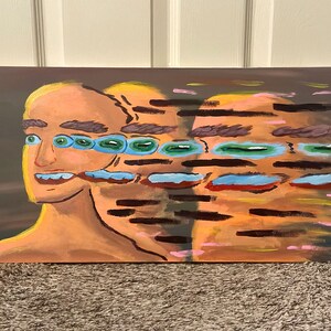 May include: Abstract painting of a person's face with multiple eyes and a blurred background. The painting is done in shades of brown, green, blue, and yellow.
