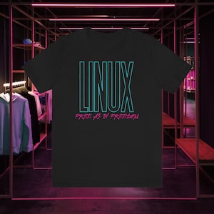 May include: Black t-shirt with a teal blue "LINUX" graphic and the text "FREE AS IN FREEDOM" in pink.