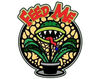 Puede incluir: Una ilustración de dibujos animados de una planta verde con dientes afilados y una lengua roja, en una maceta negra, con las palabras "FEED ME" en letras rojas y amarillas arriba.