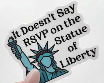 May include: A white sticker with a blue and green illustration of the Statue of Liberty holding a torch. The sticker says "It Doesn't Say RSVP on the Statue of Liberty".