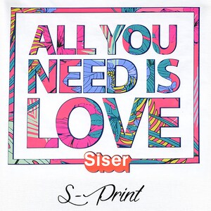 May include: White t-shirt with a pink, blue, and green floral design. The text "All You Need Is Love" is printed in a white outline with the floral design inside the letters. The text "Siser" is printed in orange below the design. The text "S-Print" is printed in black below the orange text.