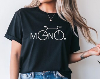 Puede incluir: Camiseta negra con un gráfico de bicicleta blanca y la palabra "MONO" en una fuente estilizada. Un pequeño corazón blanco está al lado de la última letra. La camiseta tiene mangas cortas y cuello redondo.