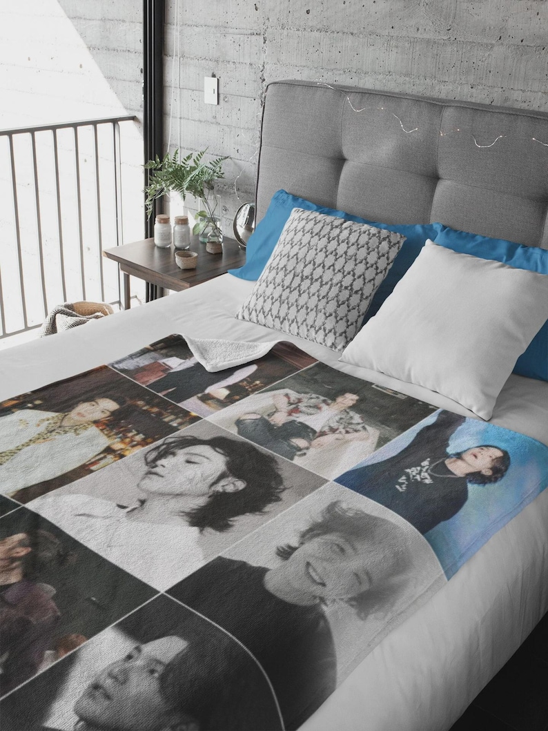 May include: A plush, rectangular blanket featuring a grid of nine photographic images of a person. The images are in various poses and styles, some in color and some in black and white. The blanket is on a bed with blue and white pillows.