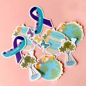 May include: A set of colorful stickers with various designs and messages. The stickers feature illustrations of butterflies, flowers, a globe, and a jar with the text "vaccinated & feinate". Other stickers include the text "it all takes time" and "public health saves lives".