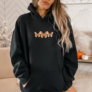 May include: Black hooded sweatshirt with a row of three orange and yellow butterflies on the front.