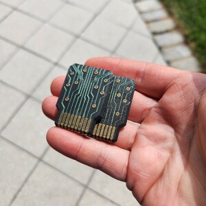 以下が含まれることがあります： 金色のコネクタと緑色の線が付いた、小さな黒い回路基板が2枚。基板は重ねられています。