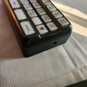 May include: Black control panel with a variety of buttons labeled with different functions, including "Howler", "Siren", "Front", "Alert", "Flash", "Horn", and "Low PWR".